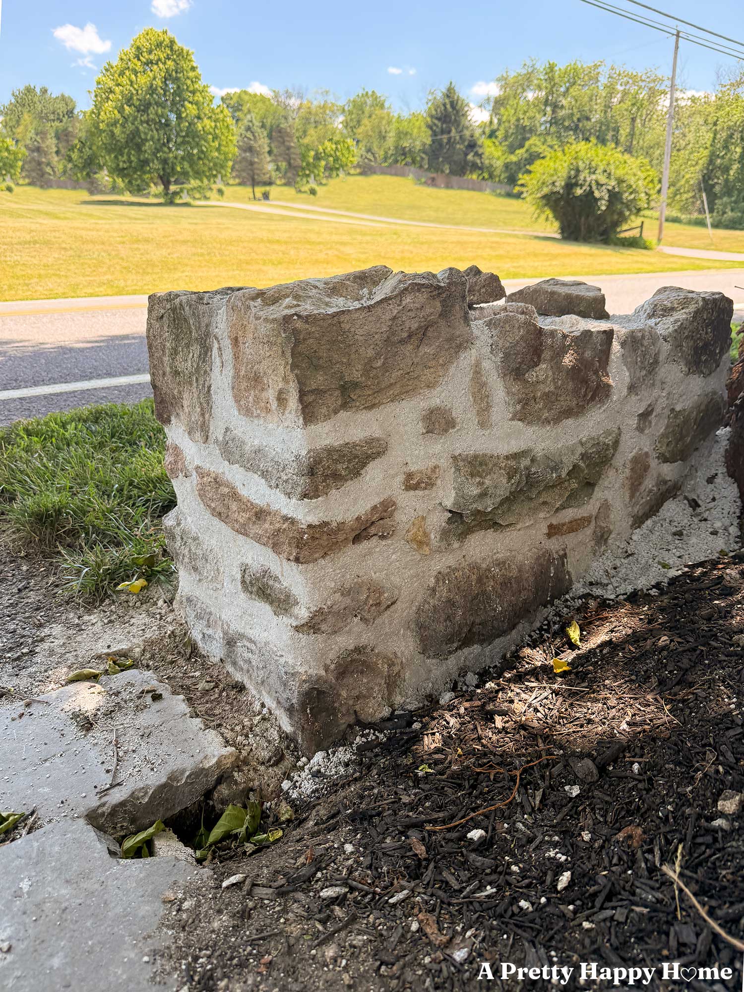 low stone wall next to a road that's being rebuilt with lime mortar