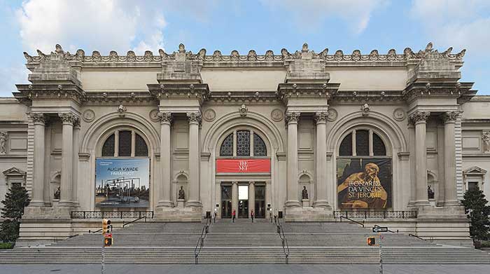 front facade of the new york metropolitan museum of art showing the unfinished columns on the facade
