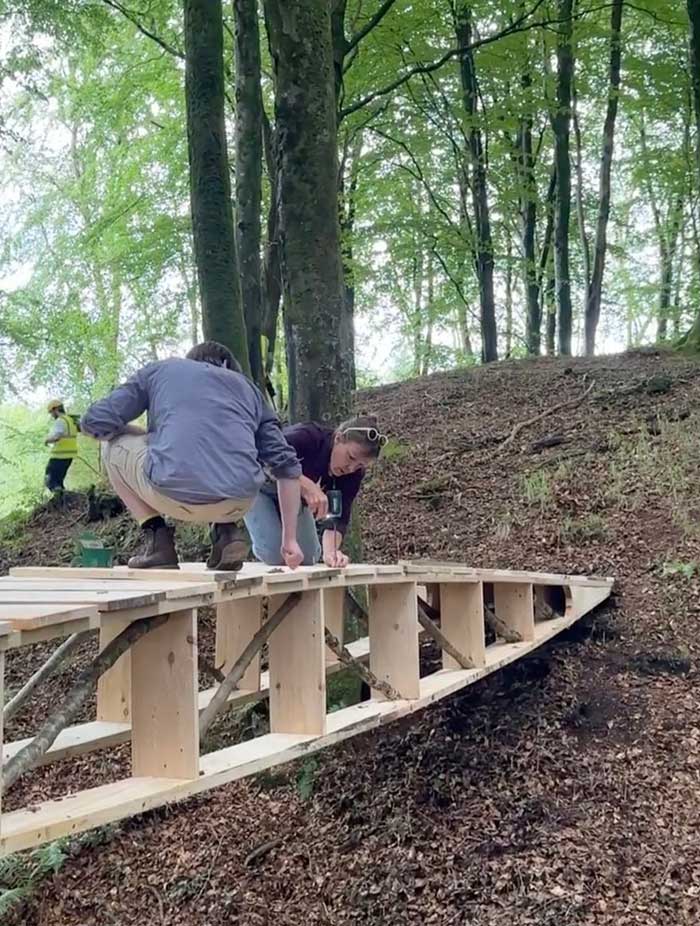 two people screwing in boards to make a bridge using scarf joints in a workshop at studio in the woods