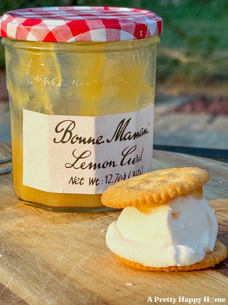 jar of bonne maman lemon curd with a lemon curd s'mores made with ritz crackers and marshmallow in front of it