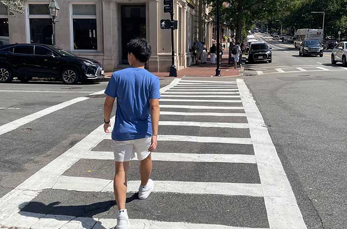 teen who invented a crosswalk signal that adapts to pedestrian speed walking across a crosswalk in an urban area