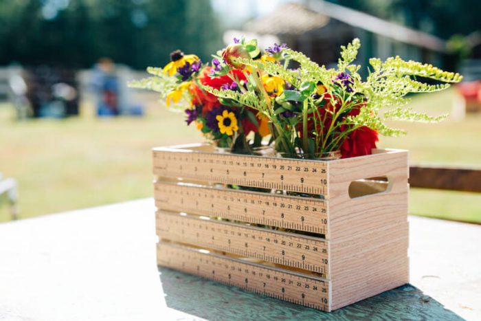 wood crate made with rulers for the slide slats. The crate is holding a colorful bouquet of flowers
