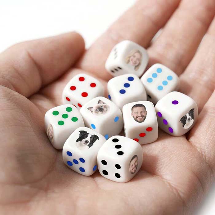 hand holding white dice with colored dots personalized with dog faces and travis kelce's face