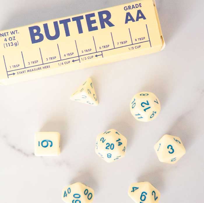 set of dice colored to look like butter and are packaged in a box that looks like a butter wrapper