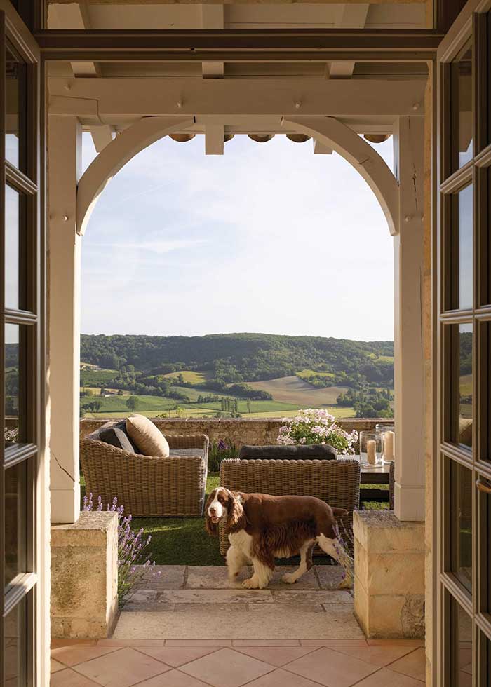 beautiful wood arched doorway with a view of the french countryside leading to an outdoor patio